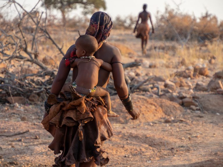 Himba-moeder met kind op haar rug